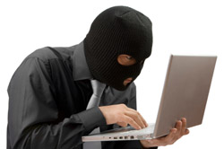 Man in a black mask on a laptop