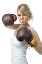 Woman with boxing gloves on ready to throw a punch